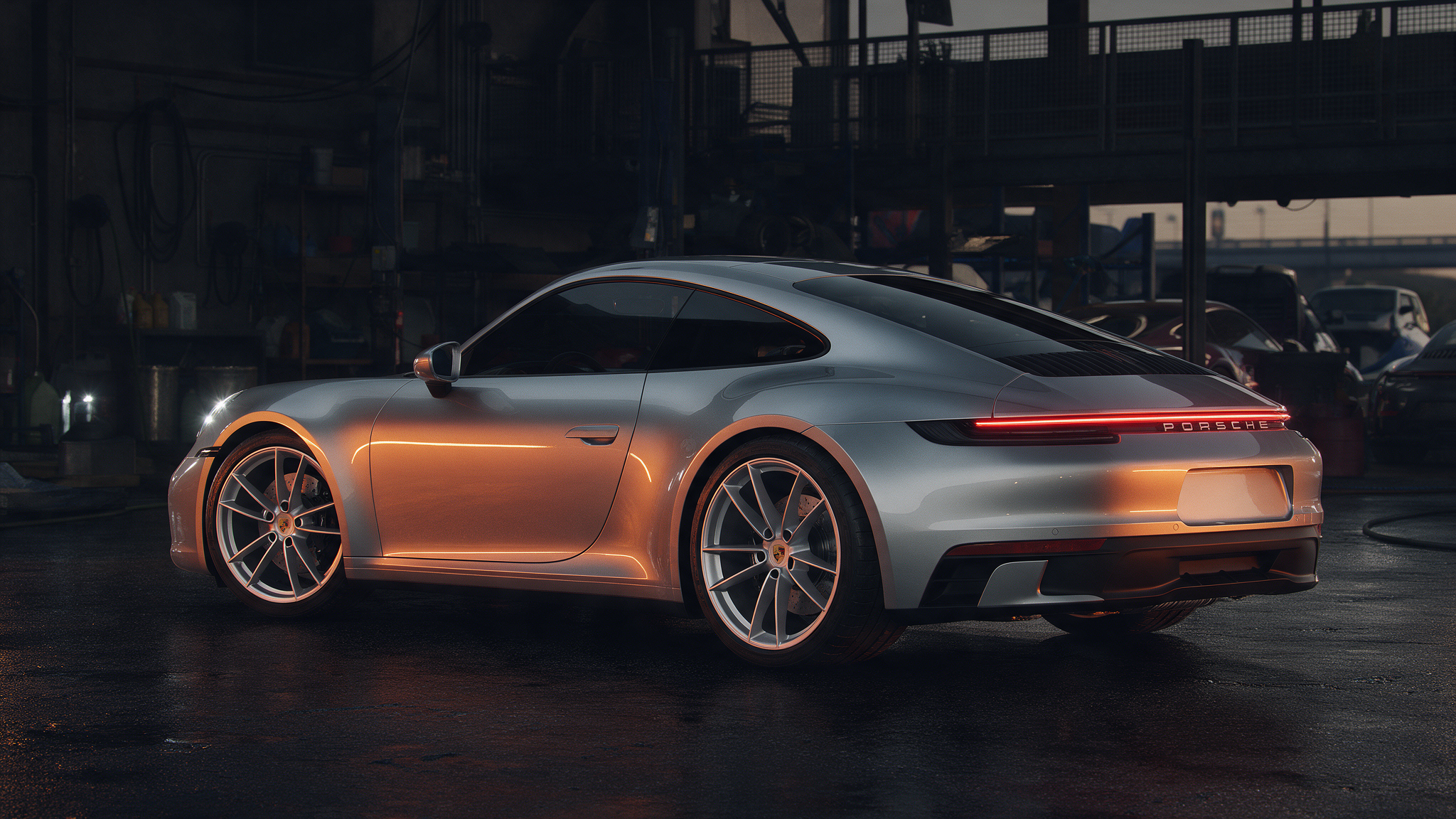 Porsche 911 992 Carrera in donkere werkplaats met oranje verlichting