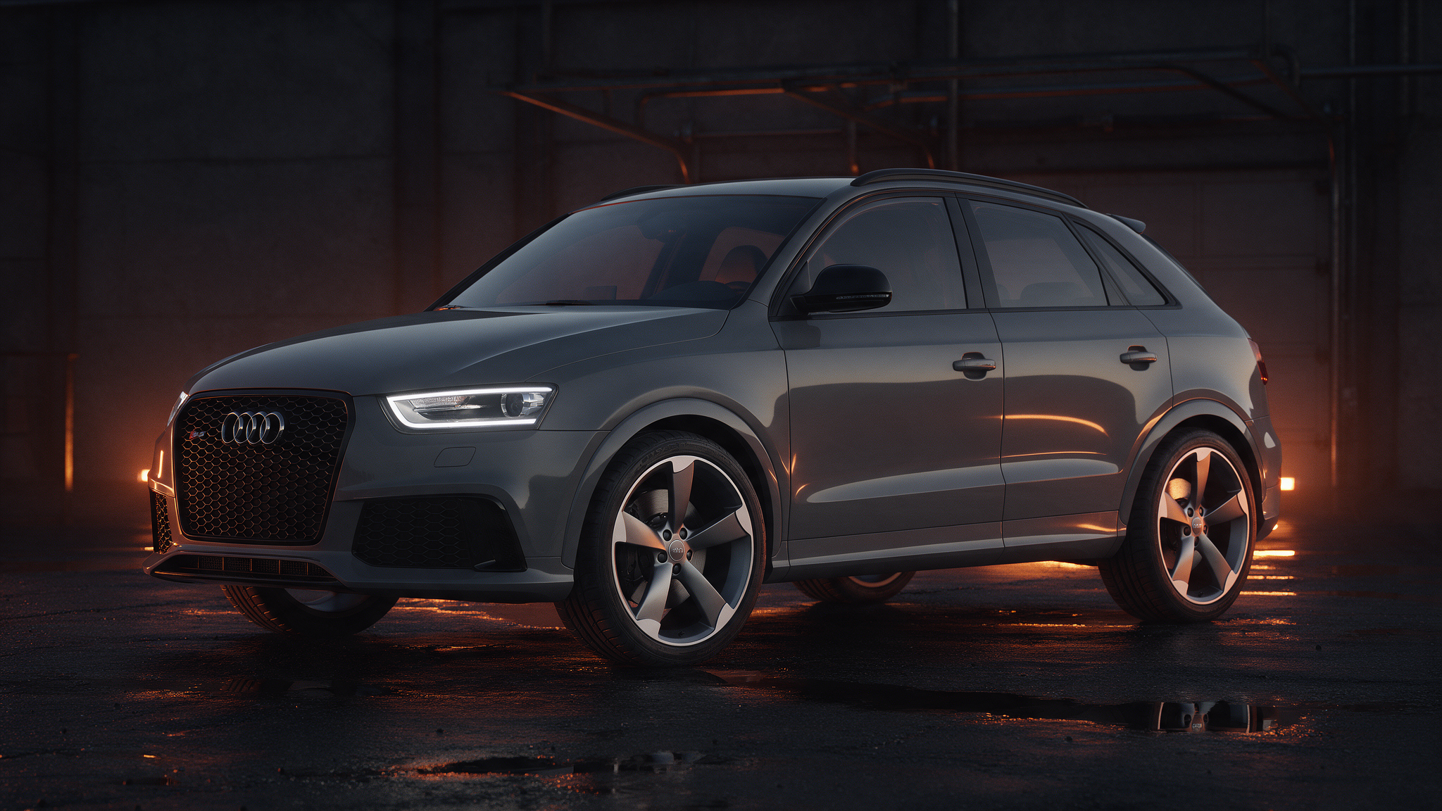 Audi RS Q3 in Nardo-grijs in een donkere werkplaats bij schemering met oranje randverlichting